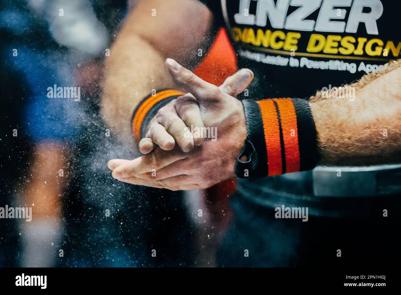 el powerlifter masculino aplica la tiza del gimnasio en las manos para el  powerlifting de la prensa del banco. Envolturas de muñequeras y singlet  Inzer Fotografía de stock - Alamy