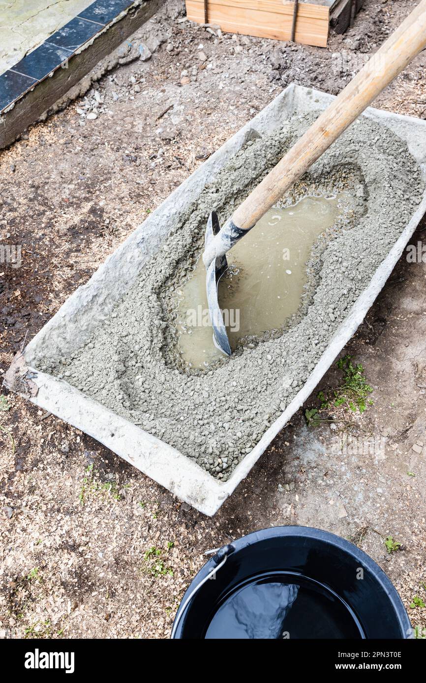 el cemento, la arena y la grava se mezclan en la cubeta para hacer concreto  en el patio trasero en el pueblo Fotografía de stock - Alamy