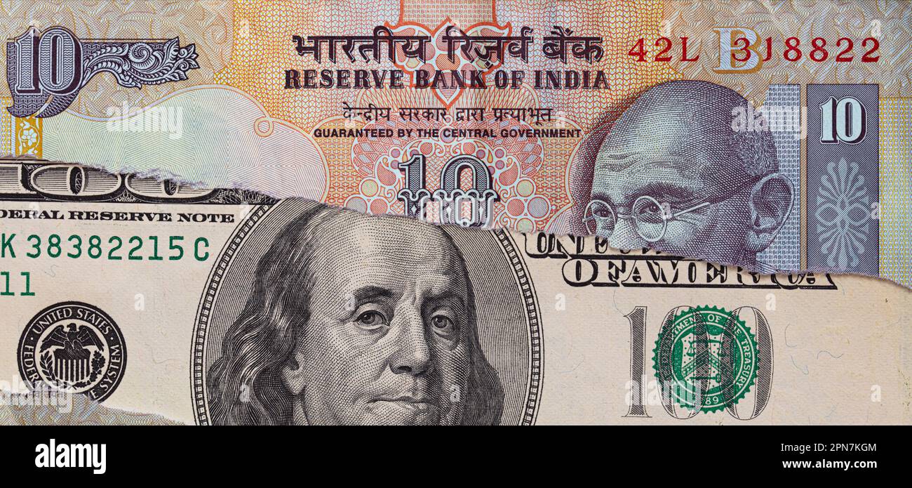 Billete de 100 dólares a través de billete de rupia india desgarrado