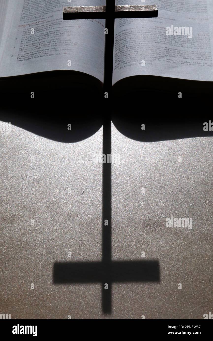 Abra la Santa biblia con la sombra de una cruz cristiana. Símbolos