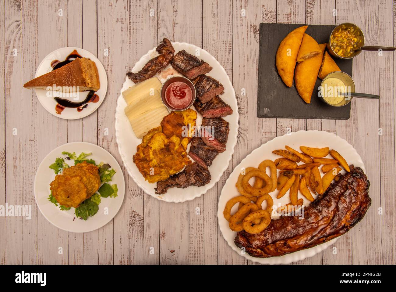 Una combinación de platos maravillosos de la cocina colombiana más parsera con carnes de carbón, empanadas de maíz con salsas de chile, una porción de quesillo A. Foto de stock