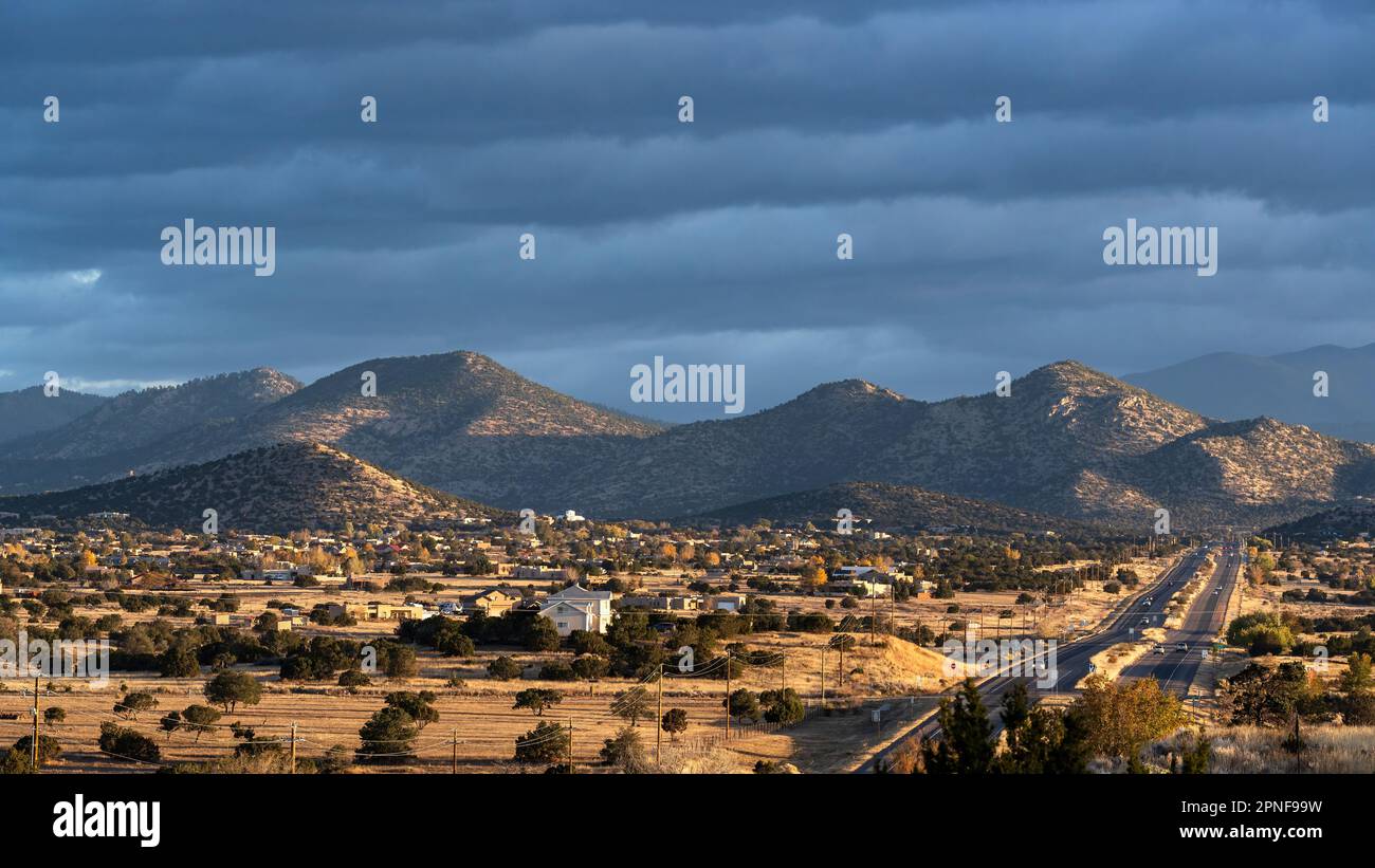 Estados Unidos, Nuevo México, Santa Fe, Sangere de Cristo montañas y edificios de la ciudad desde la carretera Foto de stock