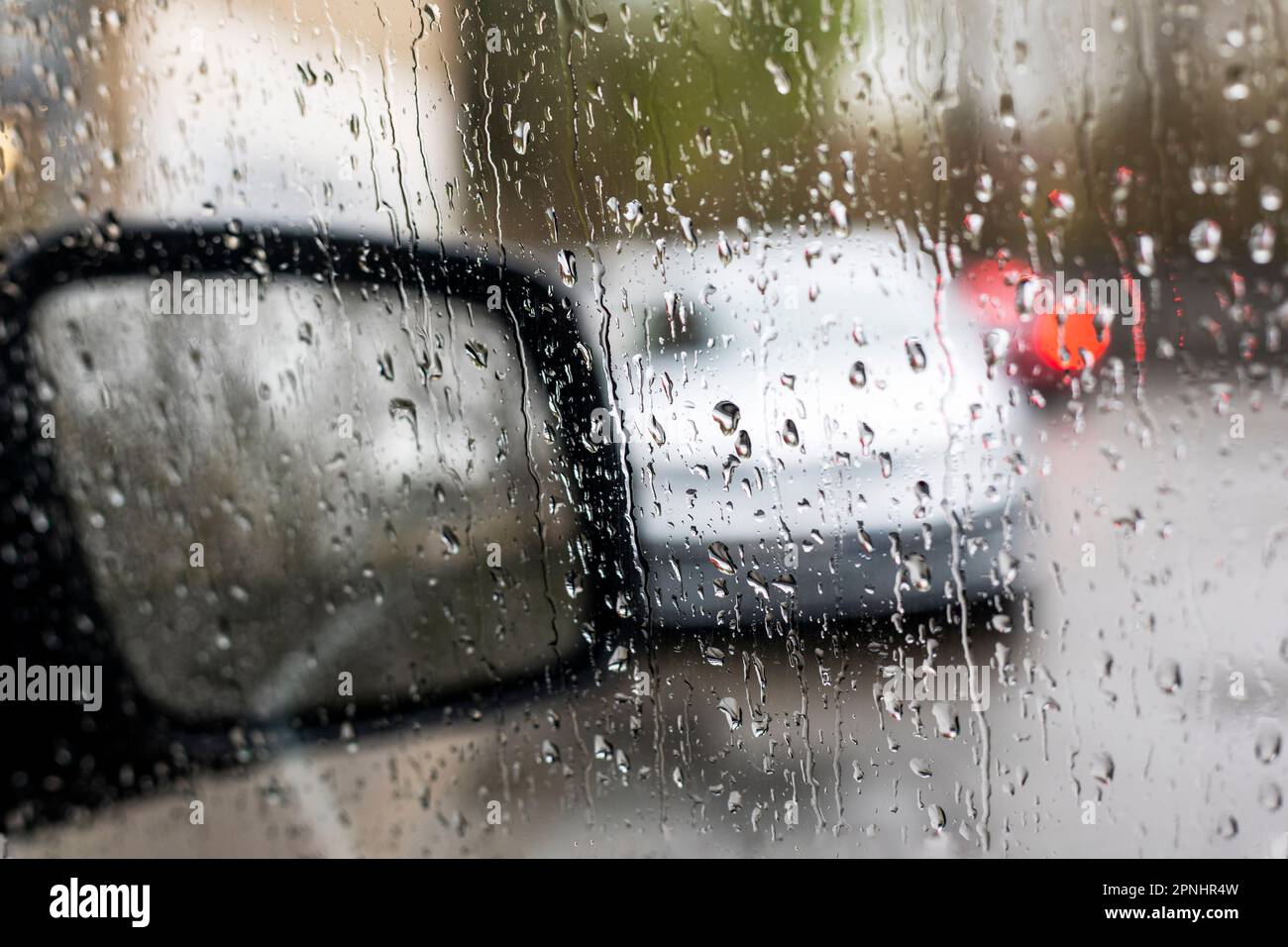 espejo derecho empañado del coche en la lluvia, mala visibilidad en la carretera. Foto de stock
