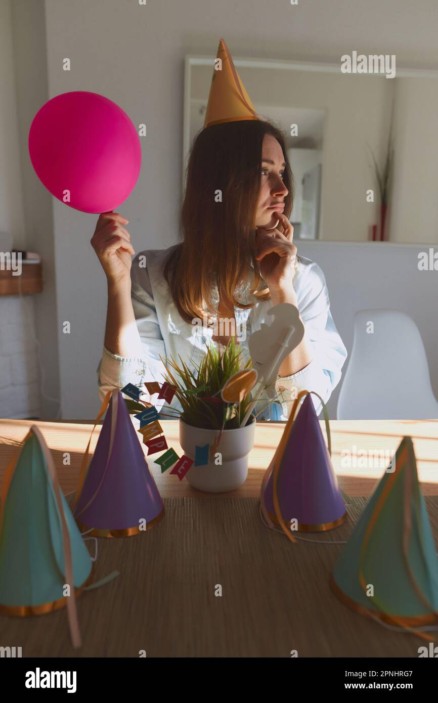 Retrato de la muchacha joven en ropa casual que se prepara para celebrar el  cumpleaños. Mujer de pie en casa durante el día con la luz del sol  Fotografía de stock -