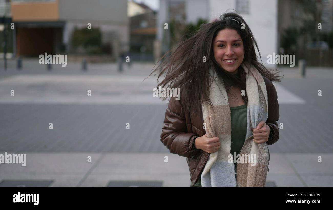 Una hermosa chica adulta morena feliz gira la cabeza en cámara lenta  mientras se ejecuta en movimiento de seguimiento disparo en cámara lenta.  Riendo mujer encantadora con b Fotografía de stock -