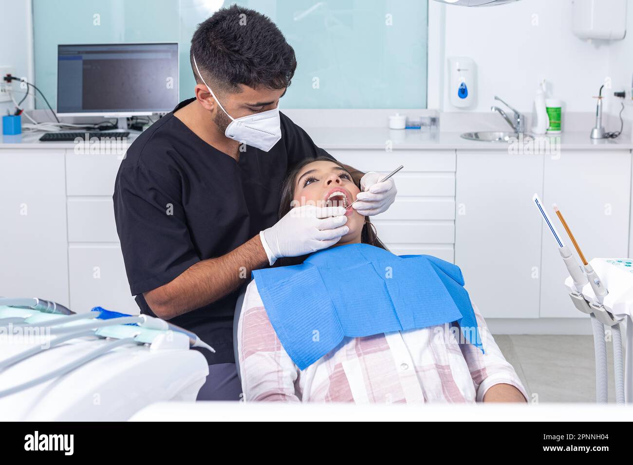Dentista masculino hispano en uniforme con guantes y mascarilla