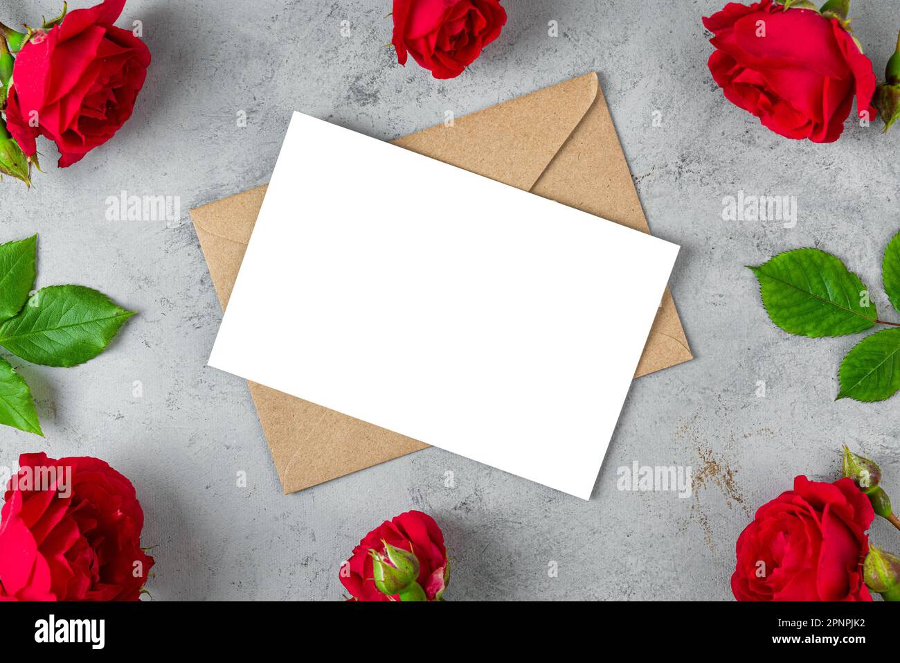 Tarjeta de felicitación en blanco en marco hecho de flores de rosa roja