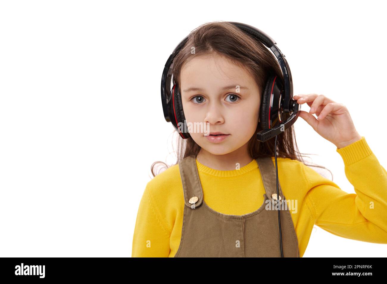 Adorable niña con auriculares para la educación en línea o el aprendizaje a  distancia, mirando a la cámara, aislado en blanco Fotografía de stock -  Alamy