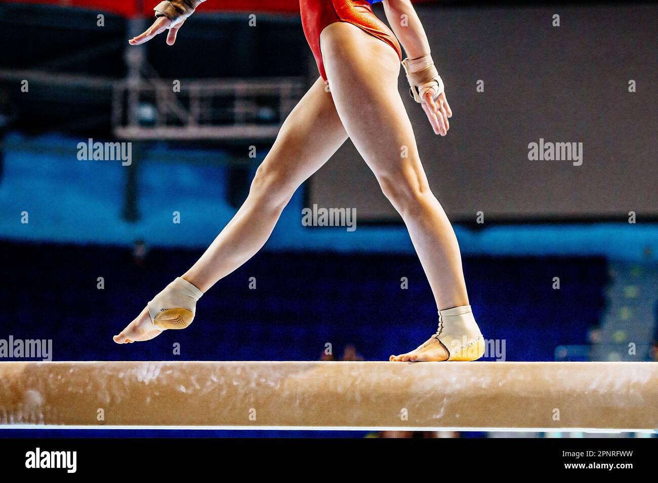 piernas gimnasta femenina paso en la viga de equilibrio en gimnasia artística, deportes juegos de verano Foto de stock