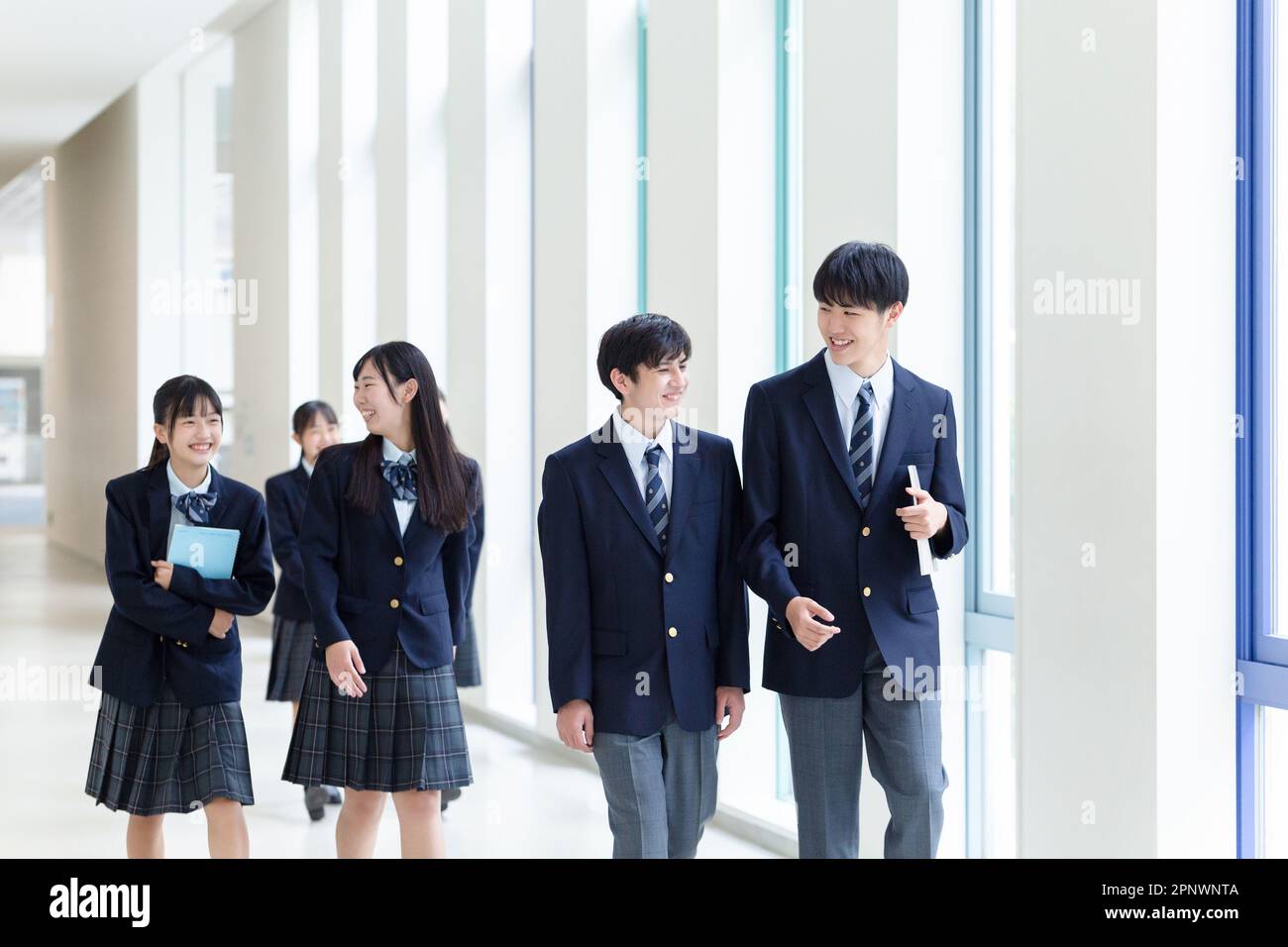 Estudiantes de secundaria caminando en el pasillo Foto de stock