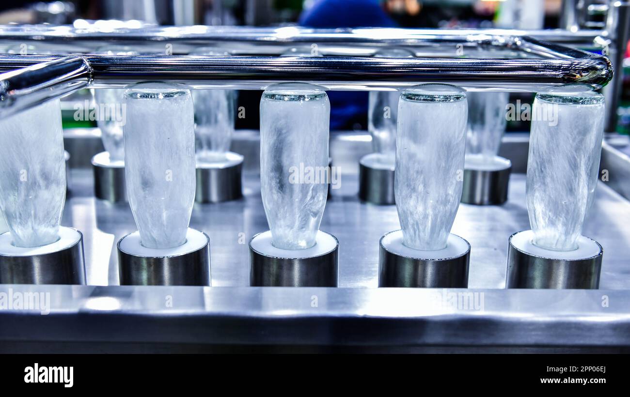 Botellas de limpieza botellas de vidrio para productos de bebidas en proceso por agua caliente en la máquina automática en la fabricación Foto de stock