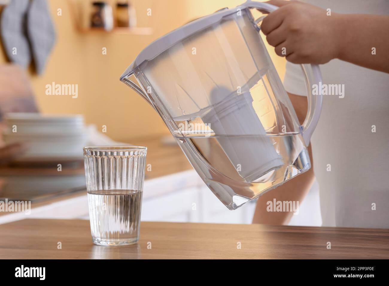 Hombre mano está vertiendo agua fría y cubitos de hielo del dispensador de  la nevera en casa Fotografía de stock - Alamy