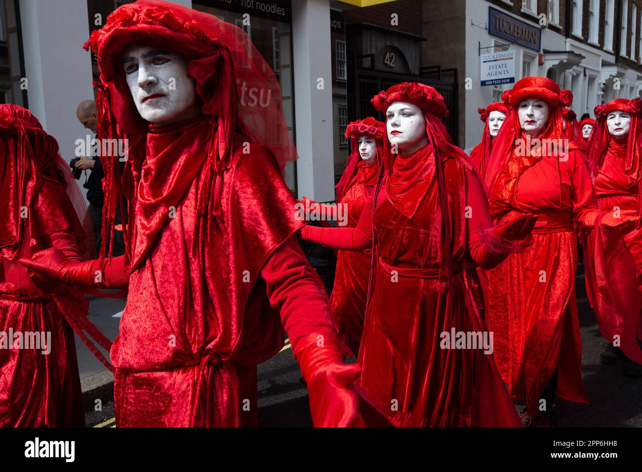 Westminster, Londres, Reino Unido. 22nd de abril de 2023. Los Rebeldes Rojos caminaron silenciosamente vestidos de rojo con caras blancas fantasmales para llamar la atención sobre el cambio climático. Miles de rebeldes de Extinction Rebellion estuvieron hoy en Westminster, Londres, en el segundo día de la acción de The Big One, Unite to Survive. Hubo una gran marcha de biodiversidad por las calles de Westminster. XR está pidiendo al Gobierno que tome medidas contra la crisis climática y que no haya nuevos combustibles fósiles. Crédito: Maureen McLean/Alamy Live News Foto de stock