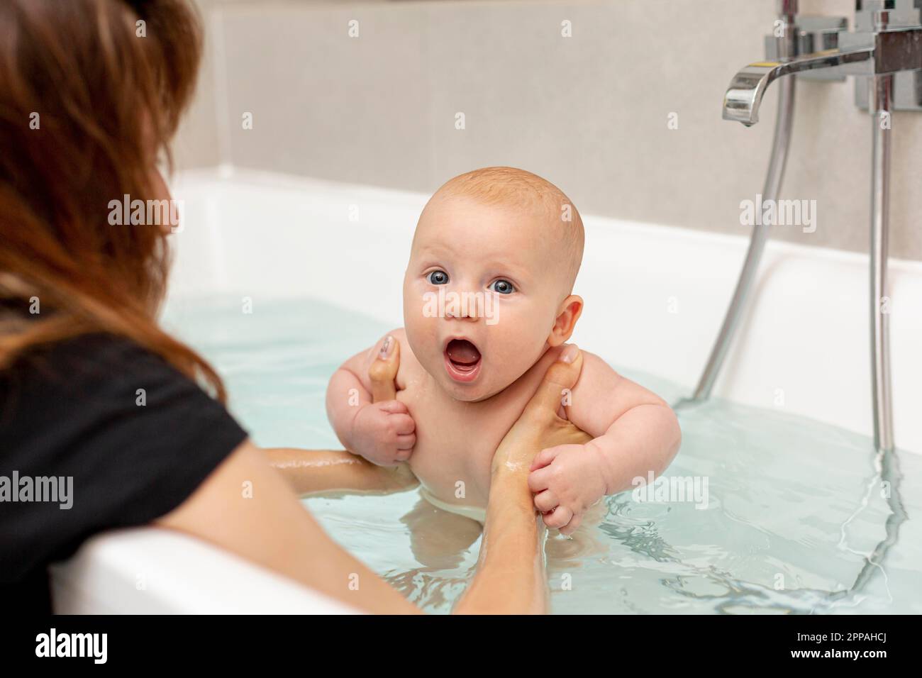 Feliz bebé lindo tomar una ducha en una bañera victoriana Fotografía de  stock - Alamy