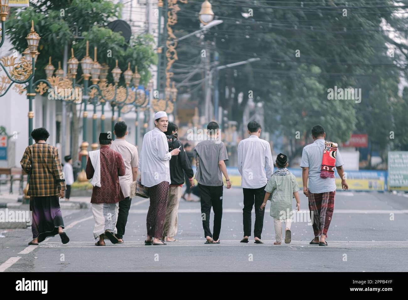 Jóvenes indonesios están caminando en el medio de la calle Kayoetangan después de hacer sholat IED o IED Mubarak oración con fondo bokeh Foto de stock