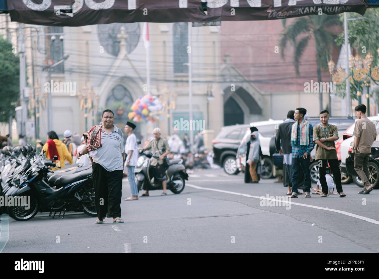 Los musulmanes indonesios se van a casa después de hacer la adoración de sholat IED o Eid Mubarak en la calle Kayoetangan con el fondo borroso Foto de stock
