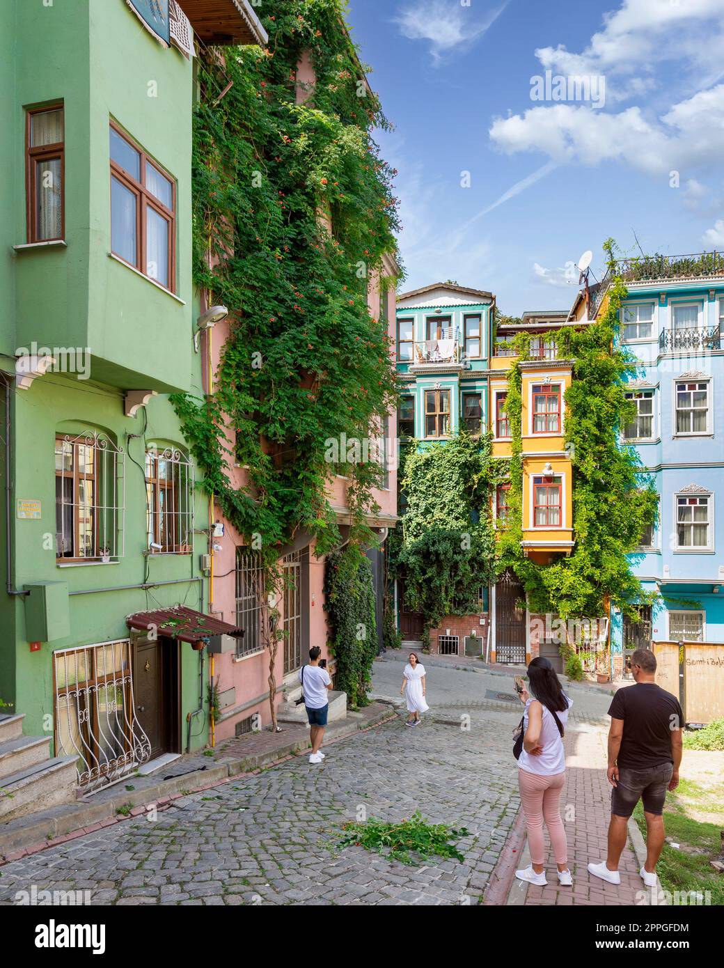 Casas antiguas tradicionales coloridas en el distrito de Balat, con turistas tomando fotos conmemorativas en un verano, Estambul, Turquía Foto de stock