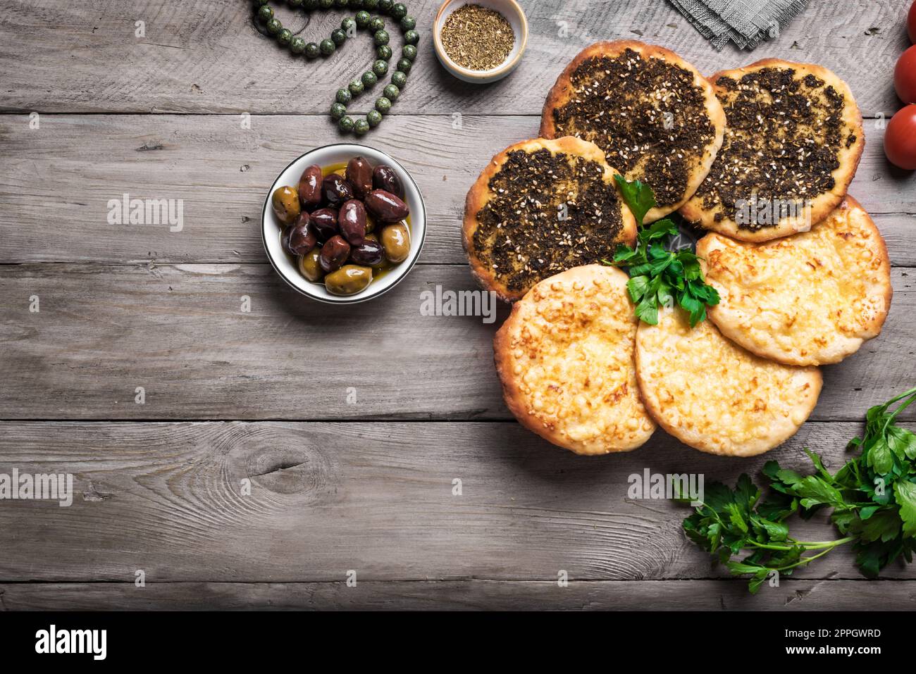 Manakeesh, pizza árabe, pan plano cubierto con especias zaatar y queso. Pan plano mediterráneo casero manakish en mesa de madera, espacio de copia. Foto de stock