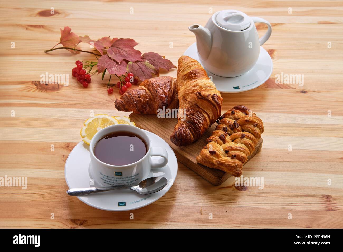 4 de octubre de 2019, Minsk, Bielorrusia - Bollo de pasas de hojaldre y crujiente croissant sobre mesa de madera con café Foto de stock