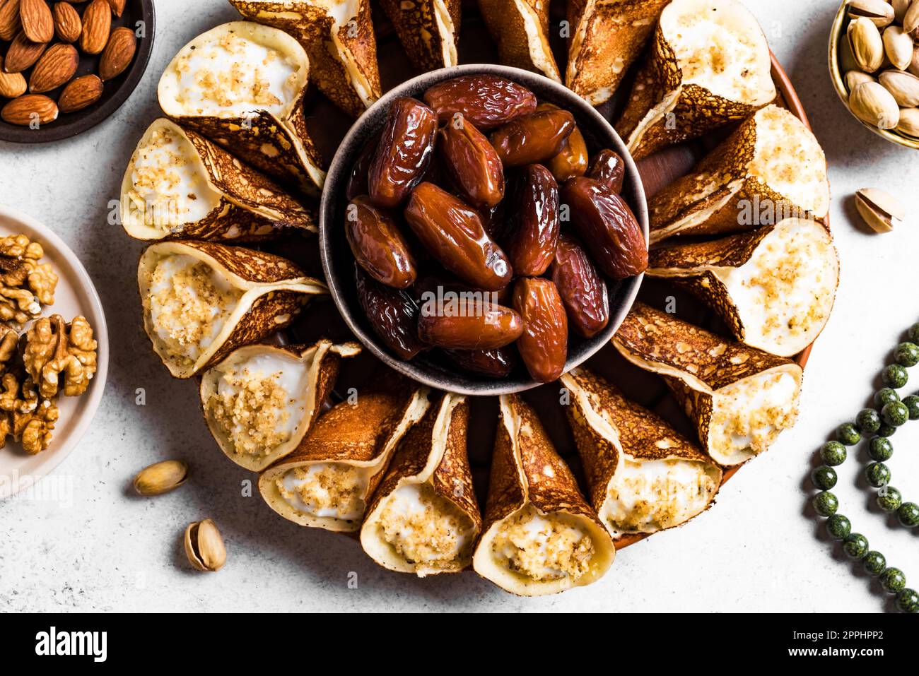 Postre iftar árabe del Medio Oriente qatayef o atayef, un pastel relleno en forma de media luna con nueces de cerca. Foto de stock