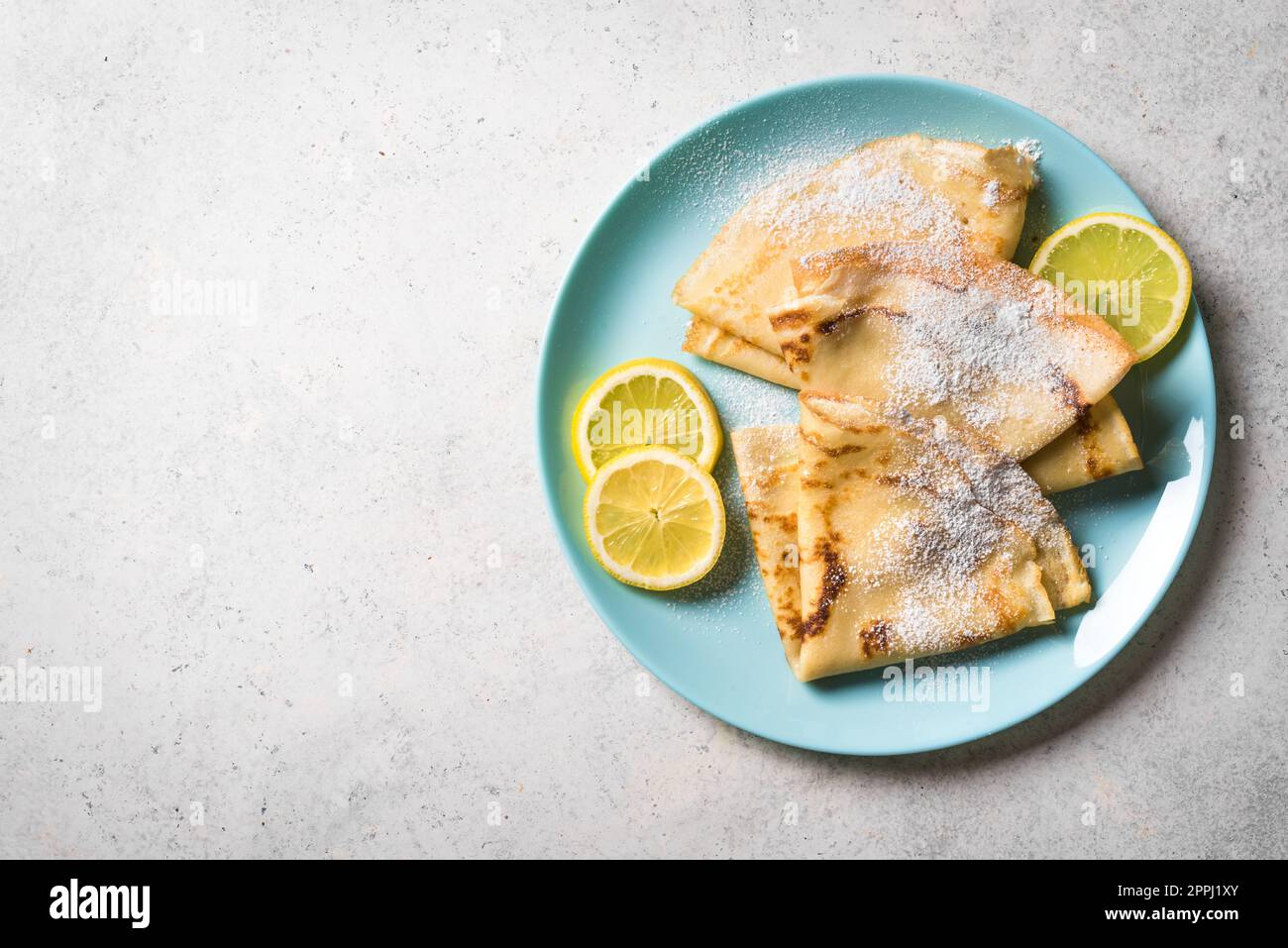 Crepes de limón sobre fondo blanco, espacio de copia. Crepes de cítricos franceses caseros para el desayuno o el postre. Foto de stock