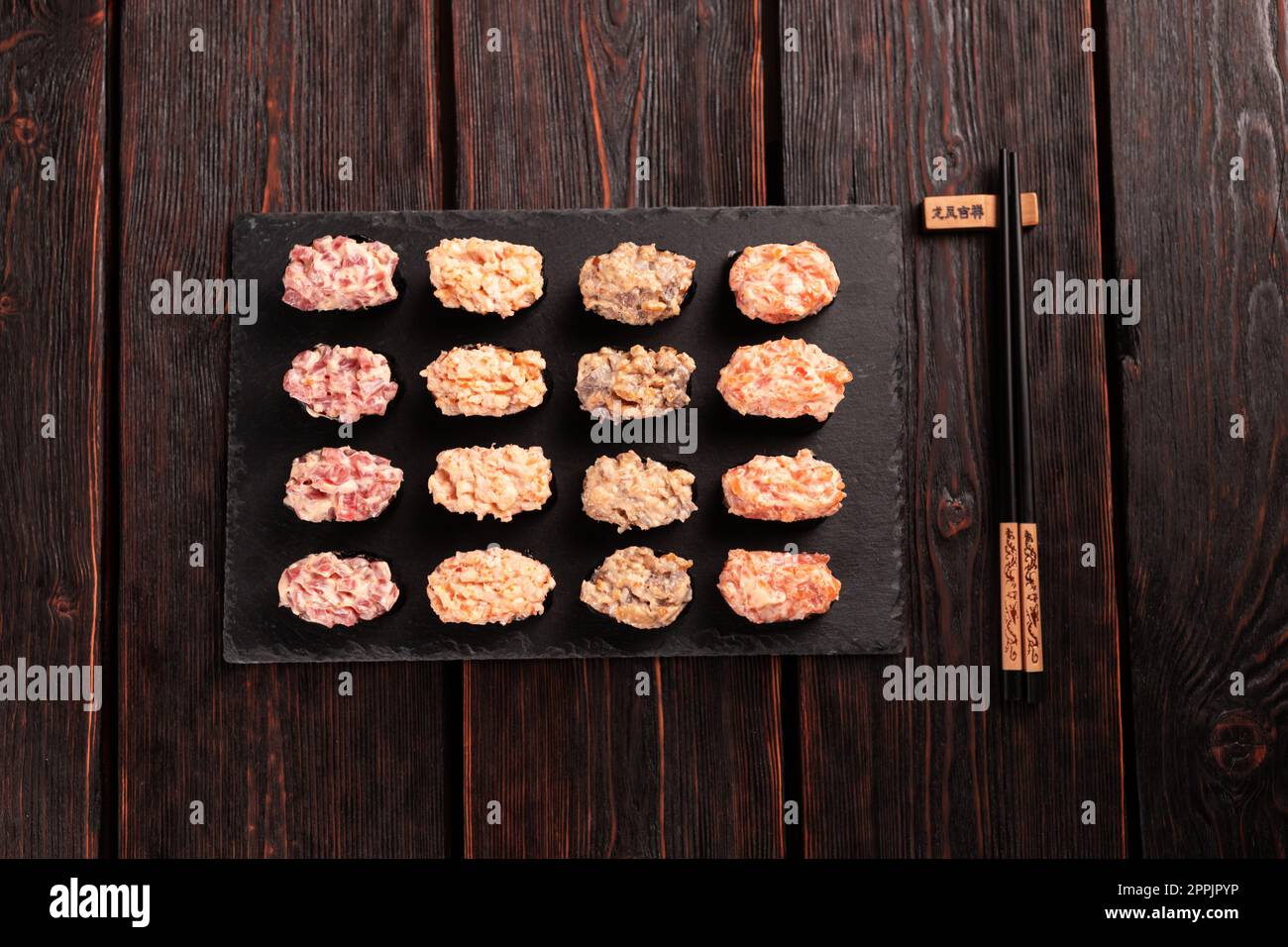 Conjunto de Gunkan Maki Sushi con diferentes tipos de salmón de pescado, vieira, perca, anguila, camarones y caviar sobre fondo de mesa de madera. Menú de sushi. Comida japonesa sushi set gunkans vista superior Foto de stock