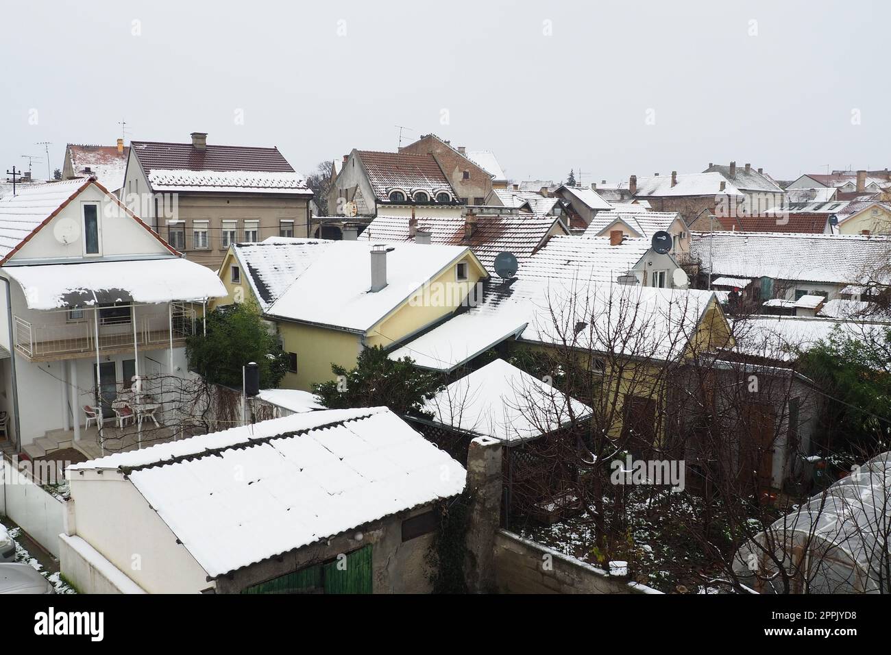 Sremska Mitrovica, Serbia, 01.27.2023 nevadas en la ciudad. Techos de casas cubiertas de nieve. Previsión meteorológica. Día nublado de invierno. Paisaje de la ciudad. Estufa de calefacción con carbón y madera. Crisis económica. Foto de stock