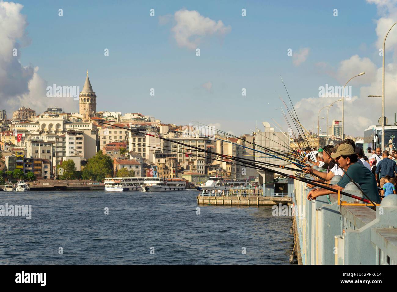 Los lugareños pescan en el puente de Gálata con el horizonte de la ciudad en el fondo, incluyendo la Torre de Gálata, Eminonu, Estambul, Turquía Foto de stock