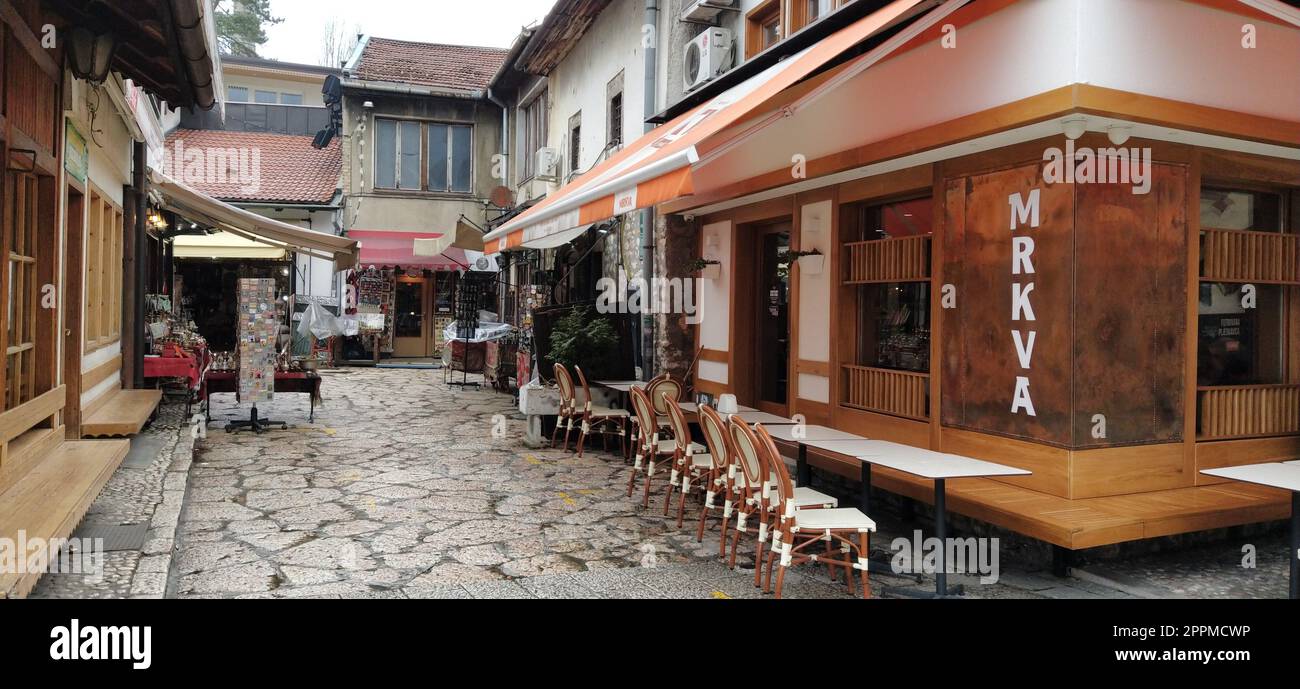 Sarajevo, Bosnia y Herzegovina, 8 de marzo de 2020, café en Sarajevo. Calles y lugares de interés, mesas y sillas esperan a los huéspedes. Clima lluvioso. Apertura temprana de la temporada turística Foto de stock