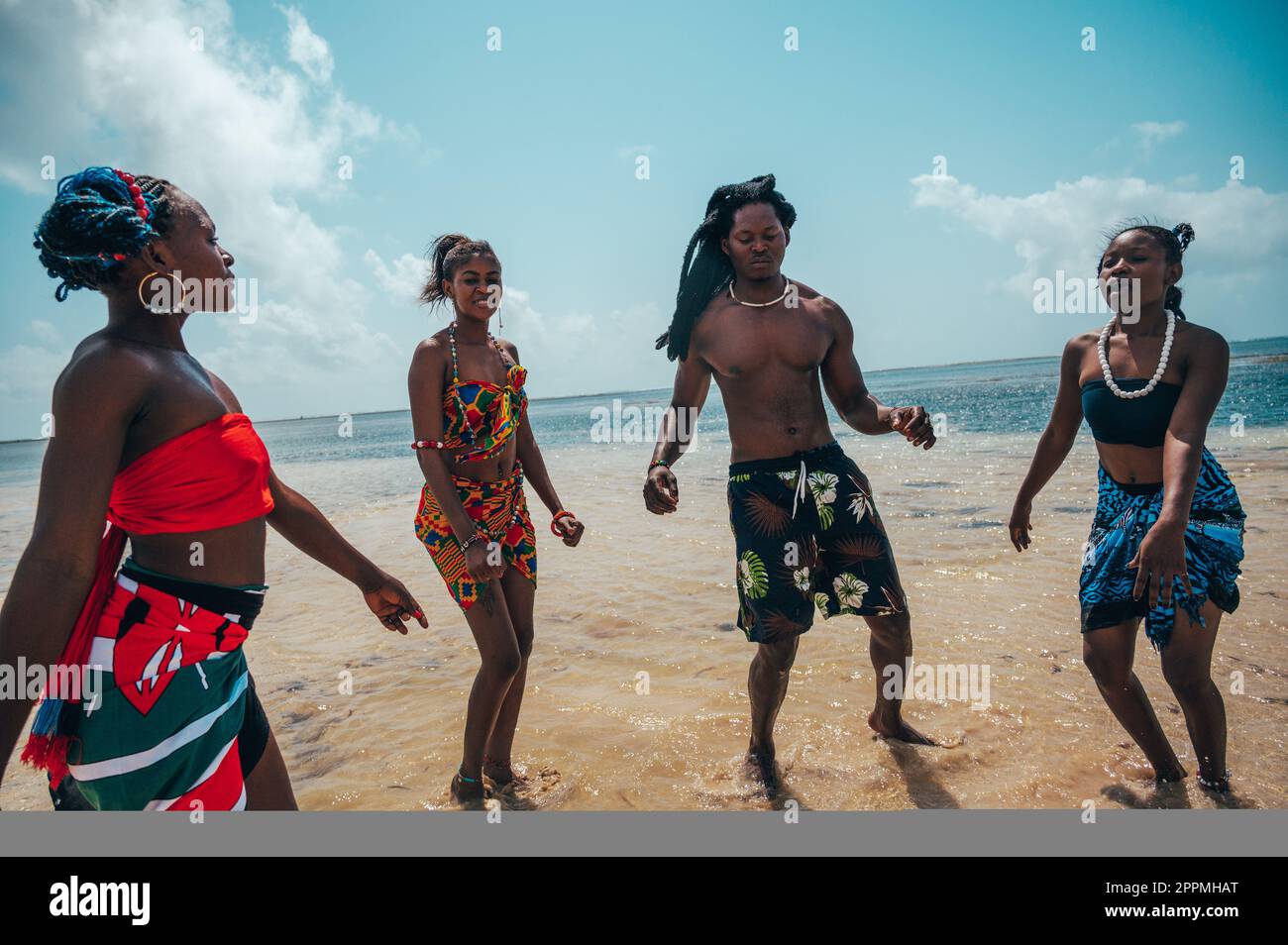 Los kenianos bailan en la playa con ropa típica local Foto de stock