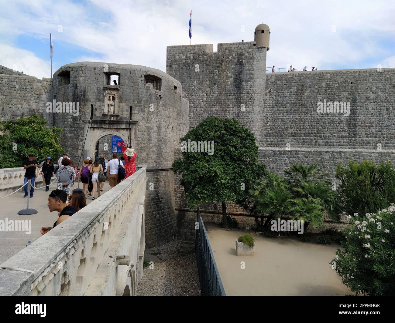 Pile Gate Dubrovnik Croacia Agosto 14 2022 personas hombres y mujeres caminan a lo largo del puente de piedra hasta la puerta de la Ciudad Vieja. Multitud de turistas. Entrada muy concurrida. La entrada principal del casco antiguo, la concurrida puerta de Pile Foto de stock