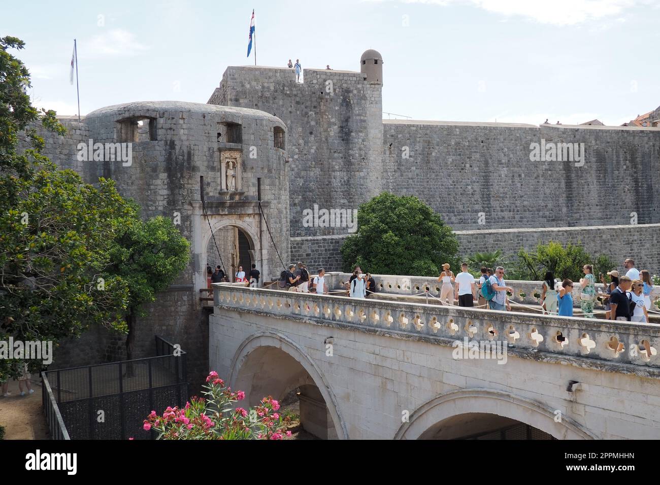 Pile Gate Dubrovnik Croacia Agosto 14 2022 personas hombres y mujeres caminan a lo largo del puente de piedra hasta la puerta de la Ciudad Vieja. Multitud de turistas. Entrada muy concurrida. La entrada principal del casco antiguo, la concurrida puerta de Pile Foto de stock