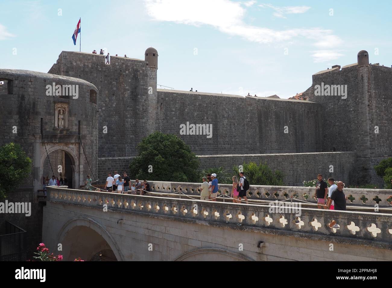 Pile Gate Dubrovnik Croacia Agosto 14 2022 personas hombres y mujeres caminan a lo largo del puente de piedra hasta la puerta de la Ciudad Vieja. Multitud de turistas. Entrada muy concurrida. La entrada principal del casco antiguo, la concurrida puerta de Pile Foto de stock