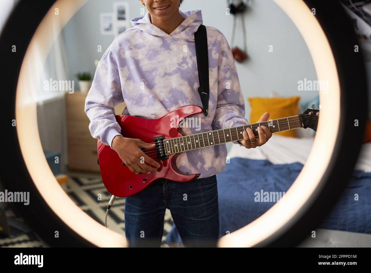 Tiro recortado del adolescente feliz con la guitarra eléctrica detrás del  marco redondo para la grabación de vídeo y tocar el instrumento musical  Fotografía de stock - Alamy