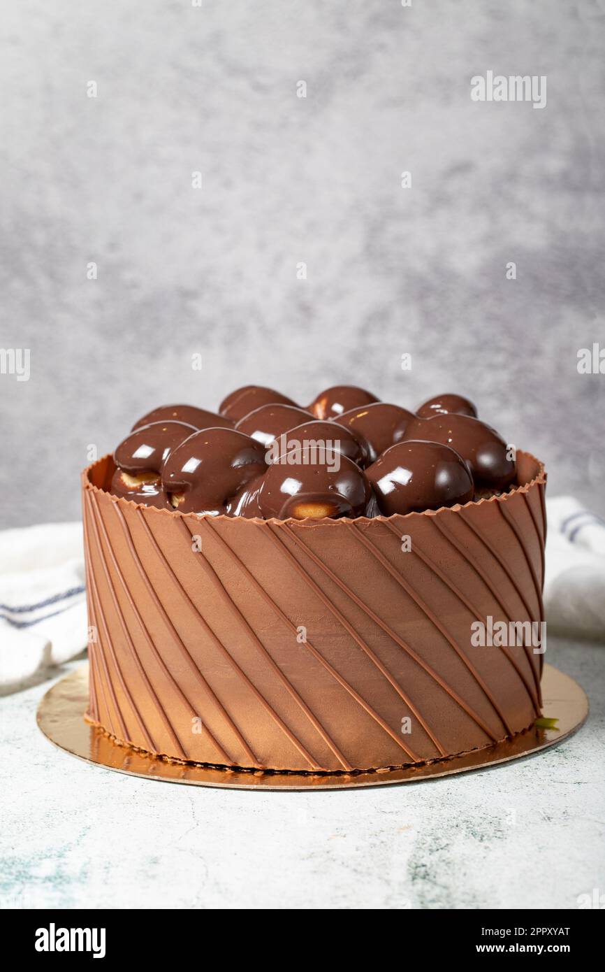 Pastel de cumpleaños profiteroles cubierto de chocolate. Pastel de crema de  chocolate sobre fondo gris Fotografía de stock - Alamy