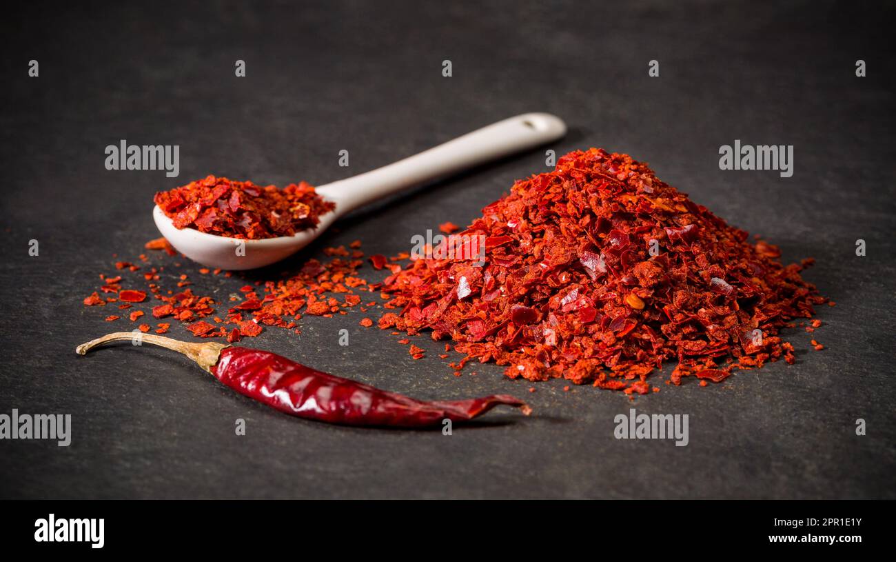 Especias de chile molido seco rojo para recetas. Una cuchara y un montón de pimienta en polvo caliente. Especia molida. Foto de stock