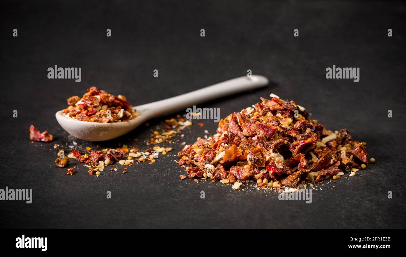 Especias de chile molido seco rojo para recetas. Una cuchara y un montón de pimienta en polvo caliente. Especia molida. Foto de stock