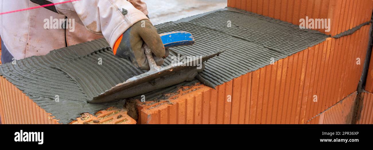 bricklayer en el trabajo en la nueva casa en construcción Foto de stock