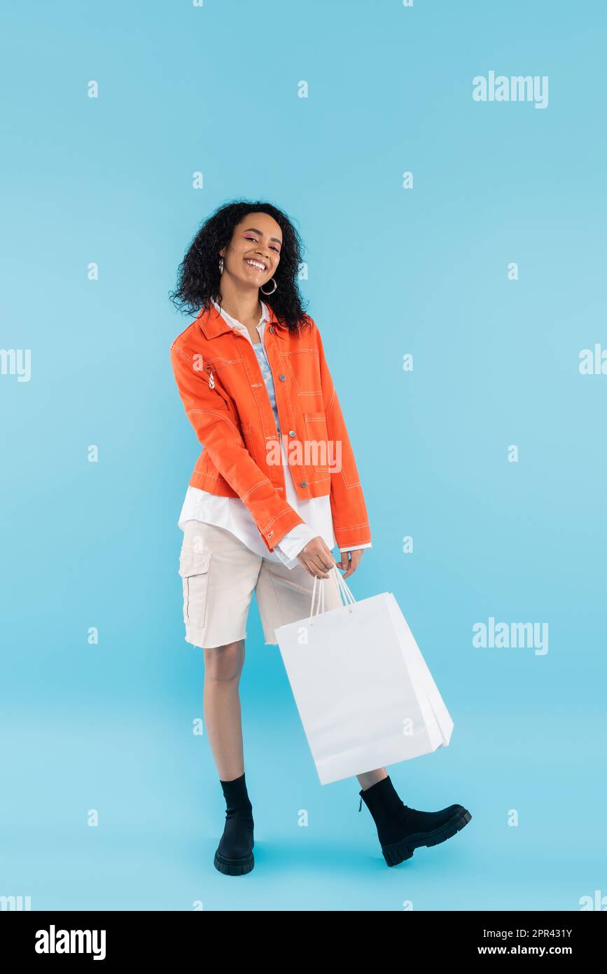 Mujer en pantalones naranjas con bolsa de compras Fotografía de stock -  Alamy