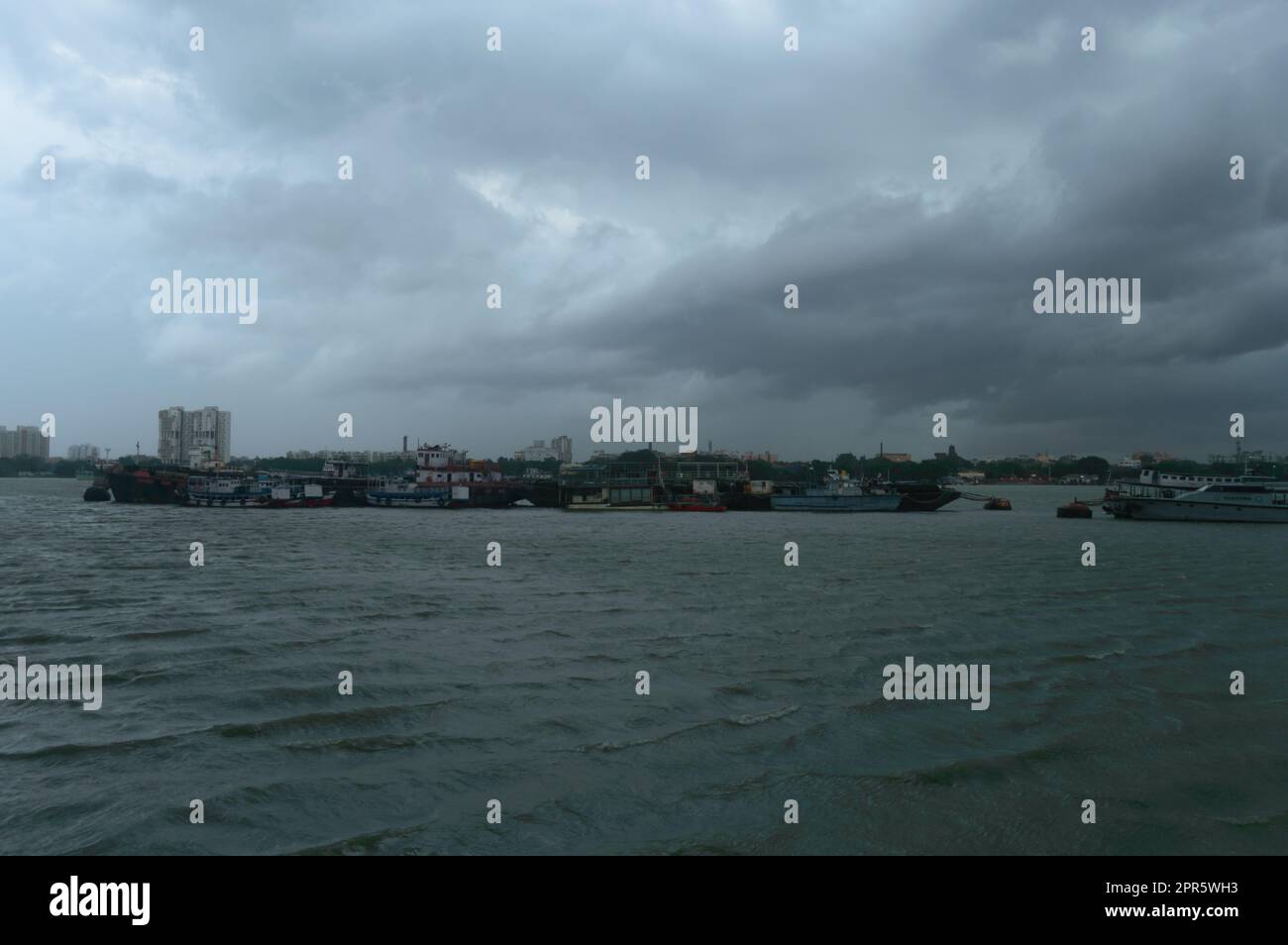 Barcos de ferry flotando sobre el río Ganges a una distancia en un día nublado dramático. Hermoso horizonte de vista de paisaje de Babu Ghat. Kolkata Bengala Occidental India Asia Meridional 19 de junio de 2022 Foto de stock