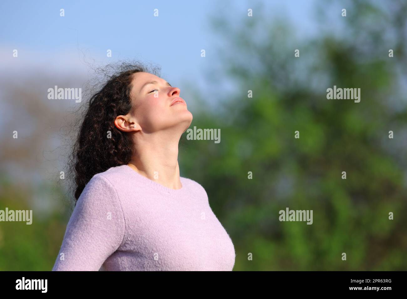 La mujer con el pelo rizado respira aire fresco Foto de stock