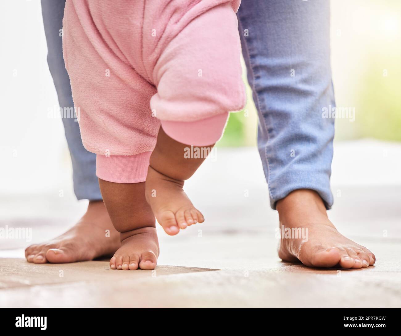 Bebé de 4 meses de edad sentado con los pies descalzos sobre una alfombra.  Juguetes en primer plano Fotografía de stock - Alamy