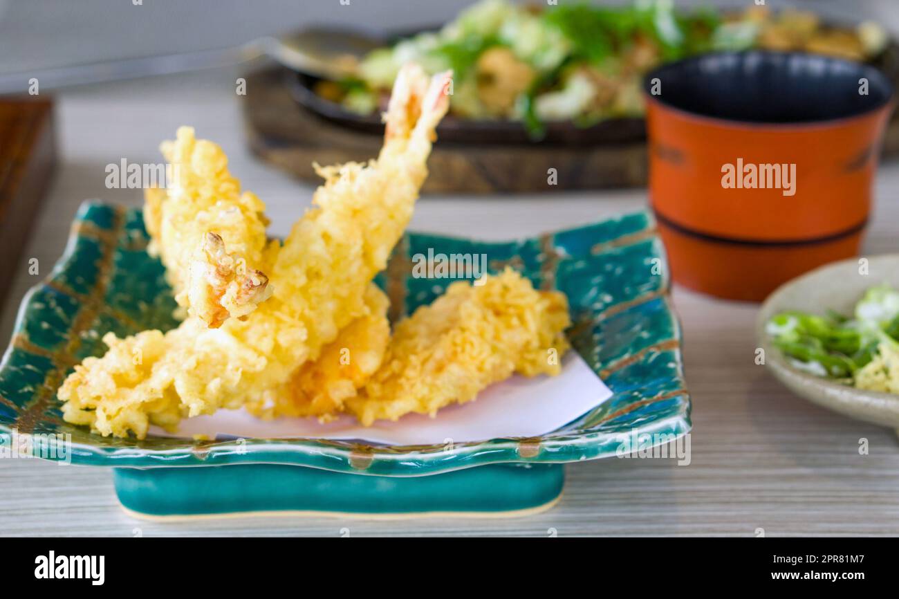 Tempura de gambas fritas en placa de cerámica. Comida japonesa sobre mesa de madera en el restaurante. Foto de stock