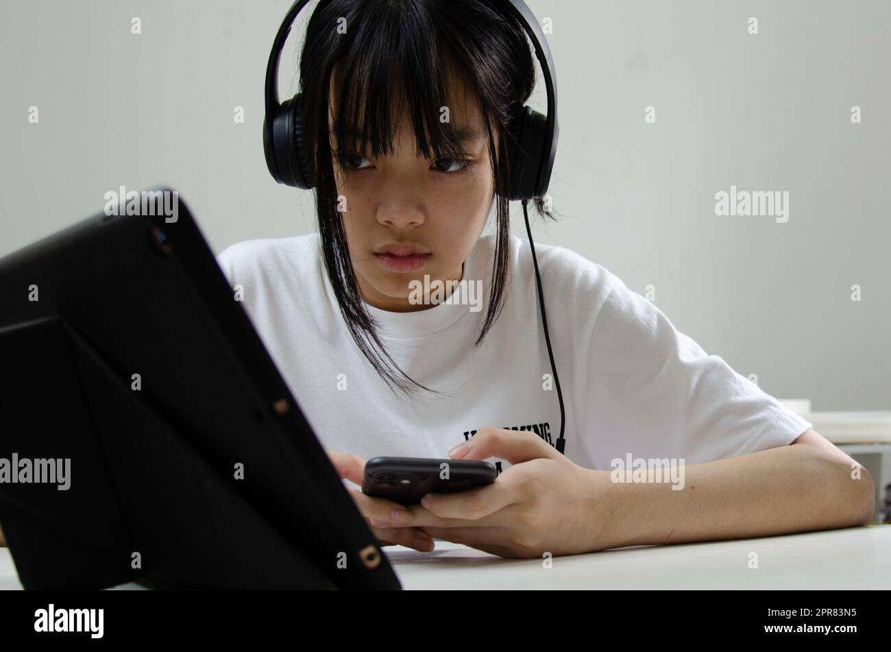 chica con auriculares estudiando en línea con el ordenador portátil y escuchar música relajante o jugar a las redes sociales de internet en casa. Foto de stock