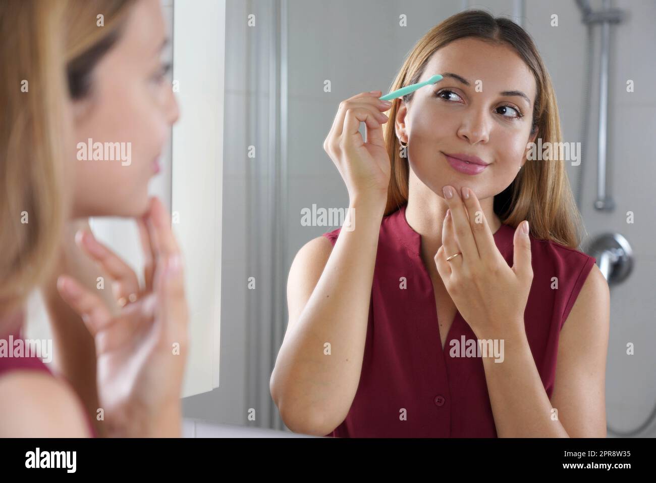 Mujer brasileña afeitándose las cejas con una navaja de afeitar en casa.  Mujer bonita usando una máquina de afeitar en el baño Fotografía de stock -  Alamy
