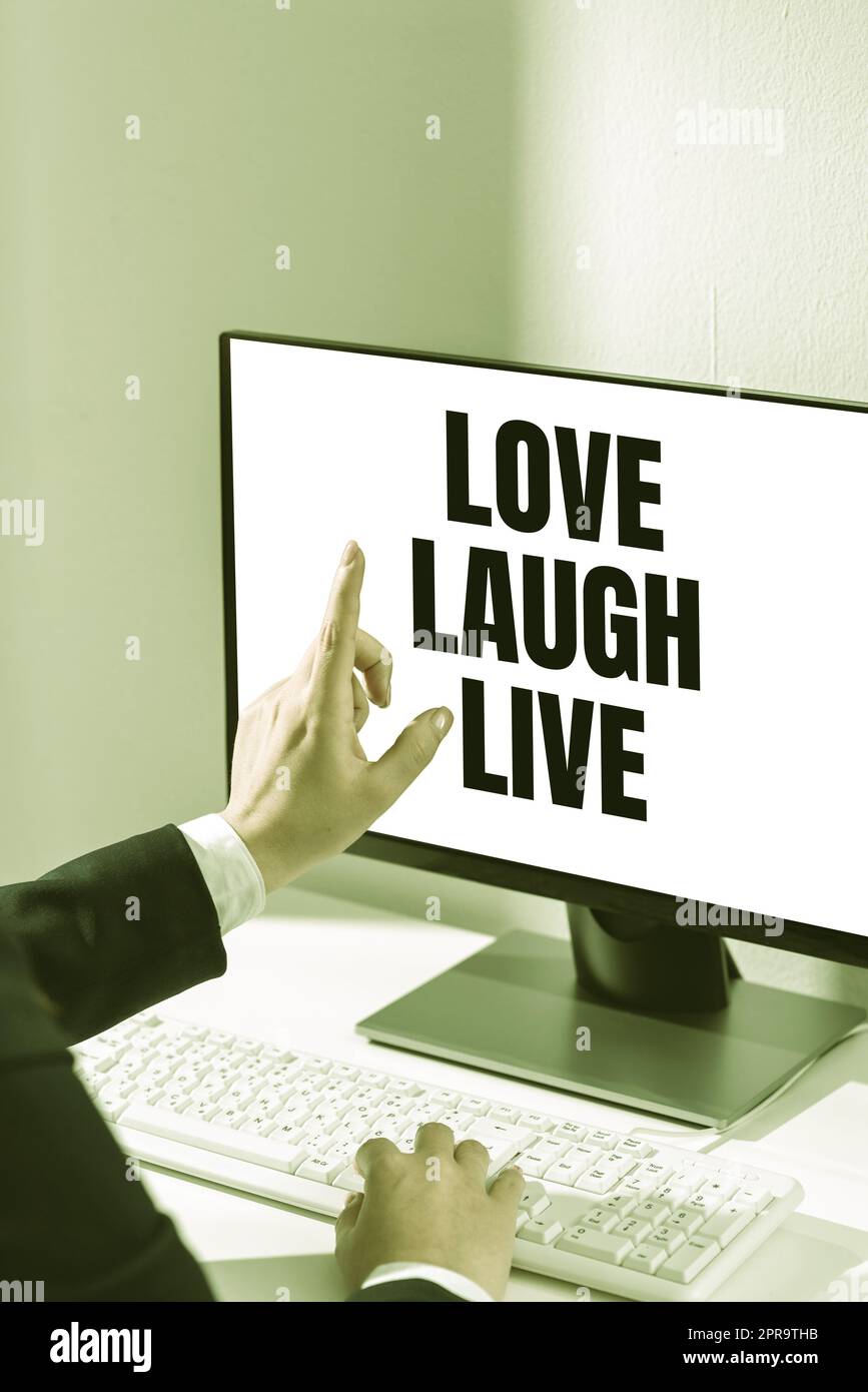 Subtítulo conceptual Love Laugh Live. Palabra para ser inspirado Positivo Disfruta tus días riendo Buen humor Mujer escribiendo Actualizaciones en Lap Top y señalando Nuevas Ideas con un dedo. Foto de stock