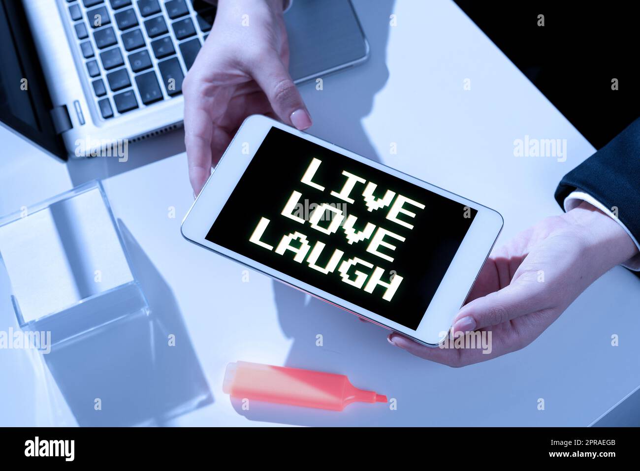 Cartel que muestra Live Love Laugh. Enfoque de negocios Sea inspirado Positivo Disfrute de sus días riendo buen humor Empresaria que presenta mensaje importante en la pantalla del teléfono móvil en el escritorio. Foto de stock