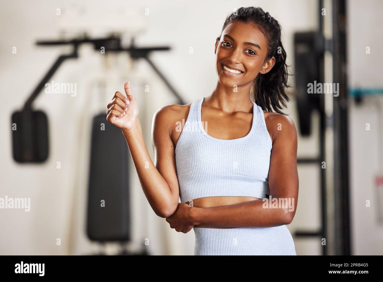 Siempre es un buen día para hacer ejercicio. Una mujer joven y deportiva  con un pulgar en el gimnasio Fotografía de stock - Alamy