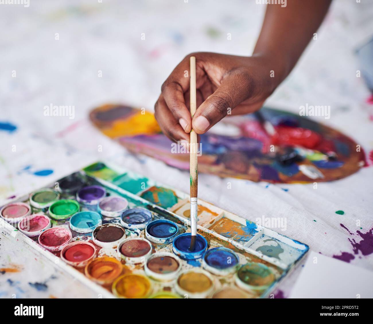 Haga el arte cada día. Una mujer irreconocible usando un pincel y una paleta de pintura. Foto de stock