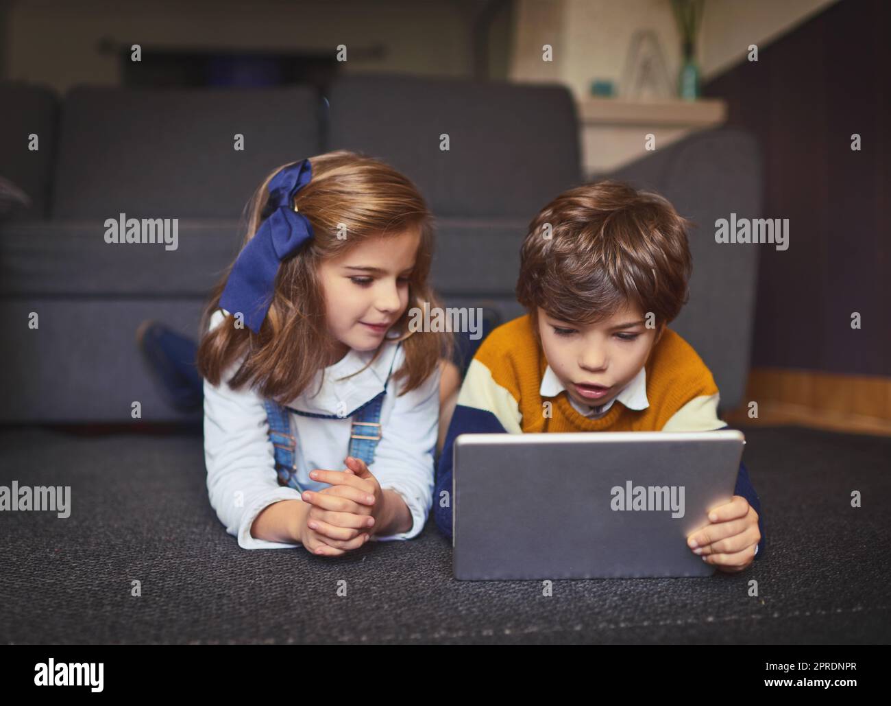 Aprender para el futuro. Niños adorables que utilizan la tecnología inalámbrica en casa. Foto de stock